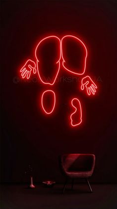 a red neon sign with two hands and an egg on it in front of a chair