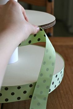 a person is using a ribbon to make a polka dot design on a table top