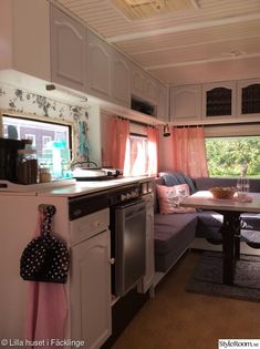 a kitchen area with a couch, table and stove top oven next to a window