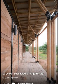 a wooden walkway lined with metal poles and wood planks on the side of a building