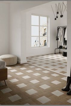 a bedroom with white walls and flooring has a large mirror on the wall next to it