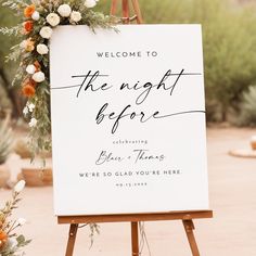 a welcome sign with flowers and greenery on an easel in front of a desert backdrop