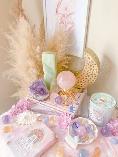 a table topped with lots of candy and other items next to a framed picture on the wall