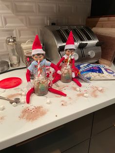 two elfs sitting on top of a kitchen counter