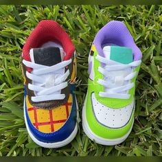 two pairs of colorful shoes sitting in the grass