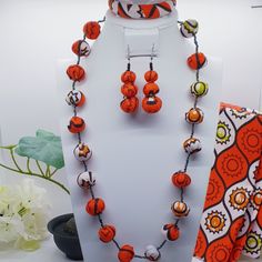 "This vibrant authentic African hand-crafted beaded necklace ,earrings and bangle set is the perfect addition to your wardrobe and perfect unique gift for her! Size: Necklace: 11\" Length & 8\" Width Earrings: 2.2\" Bangle: 2.6\" Diameter Color: Red & White Shape: Round beads Material: African Ankara fabric beads & glass seed beads with barrel screw twist clasps. Due to screen resolution, color may appear different than the actual product. Fabric patterns may not look identical due to variances Adjustable Orange Jewelry For Festivals, Wooden Round Beads Jewelry For Festivals, Festival Jewelry With Round Wooden Beads, Wooden Beaded Round Jewelry For Festivals, Round Wooden Beads Jewelry For Gifts, Handmade Adjustable Jewelry Sets With Round Beads, Orange Jewelry With Wooden Beads For Gifts, Unique Orange Jewelry With Wooden Beads, Orange Jewelry With Wooden Beads As A Gift