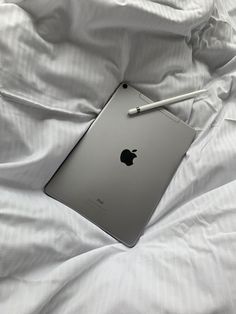 an apple ipad sitting on top of a bed