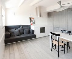 a kitchen with a couch, table and chairs in the corner next to each other