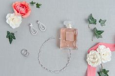 an assortment of jewelry and flowers on a gray surface with pink ribbon around the neck