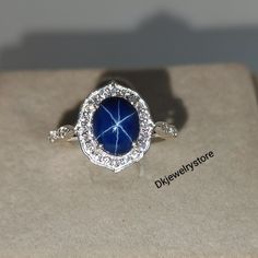 a blue ring with diamonds on it sitting on top of a cardboard box in front of a white background