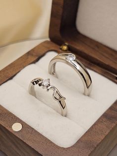 two wedding rings sitting in a wooden box