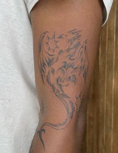 a man's arm with a dragon tattoo on the left side of his arm