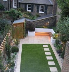 a small backyard with grass and landscaping