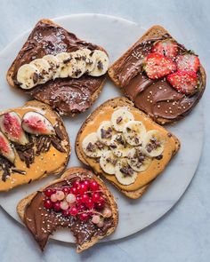 four pieces of toast with chocolate and fruit on them