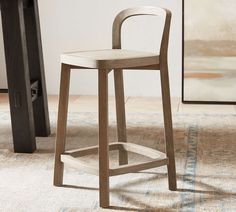 a wooden bar stool sitting on top of a rug