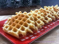 three waffles are on a red plate with snowflakes in the background