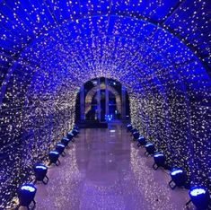 the inside of a tunnel covered in blue lights