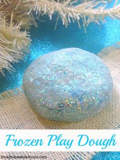 the frozen play dough is next to a white christmas tree with blue and silver ornaments