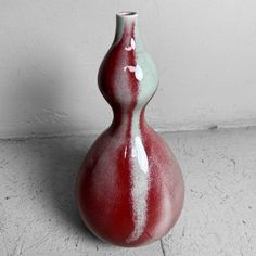 a red and white vase sitting on the floor