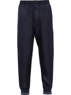 Navy/cobalt blue silk side stripe tapered track pants from PRADA featuring mid-rise, elasticated waistband, tapered leg, side stripe detailing, silver-tone logo plaque and two rear welt pockets. | Prada Side Stripe Tapered Track Pants Prada Men, Blue Silk, Side Stripe, Mens Sweatpants, Men Clothing, Welt Pockets, Tapered Legs