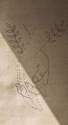 someone's hand is drawn on the ground next to a rug with leaves and arrows