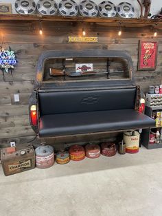 an old pickup truck is parked in a garage with other items on the wall behind it