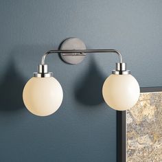 two lights are on the wall in front of a mirror with a map behind it