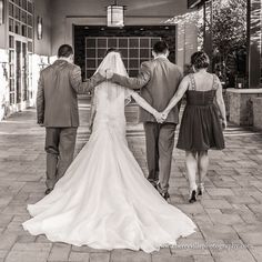 a bride and groom walking down the street with their arms around each other as they hold hands