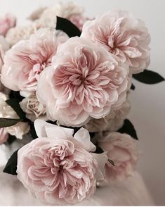 pink and white flowers in a vase on a table