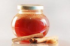 a glass jar filled with liquid and cinnamon sticks