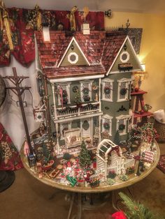 a doll house is on display in a room with christmas decorations and other things around it