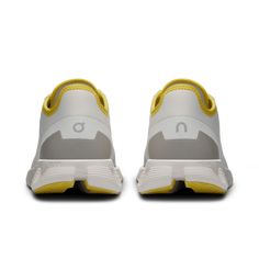 a pair of white and yellow sneakers on a white background with the bottom part of the shoe