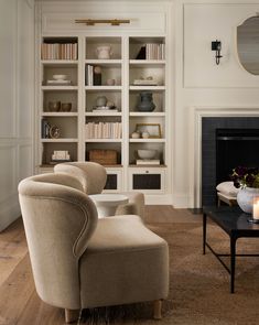 a living room filled with furniture and a fire place in front of a book shelf