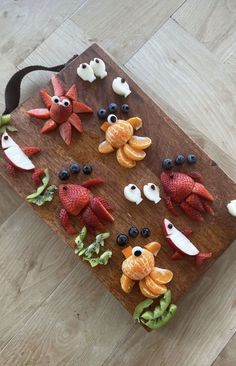 a wooden cutting board topped with fruits and vegetables