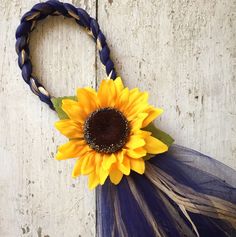 a yellow sunflower is attached to a blue tulle