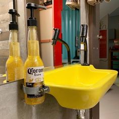 a yellow sink sitting next to two bottles of beer