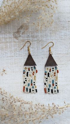 When creating these earrings I wanted to design a pattern and use a mix of colors that would enable these earrings to go with almost any outfit. These earrings are beaded by hand and the topper is made out of genuine leather. You can choose between gold, silver, and bronze hardware that is hypoallergenic.  Approx. 3 inches long Note: If you would like different colors please do not hesitate to reach out. We love custom orders and have an array of colors. Handmade Brown Heishi Beads, Brown Dangle Beaded Earrings With Tiny Beads, Unique Adjustable Beaded Earrings With Dangling Beads, Artisan Beaded Heishi Beads Earrings, Artisan Beaded Earrings With Heishi Beads, Handmade White Heishi Beads Earrings, Bohemian Heishi Beaded Earrings With Dangling Beads, Bohemian Beaded Earrings With Dangling Heishi Beads, Unique Tiny Beaded Earrings For Festival