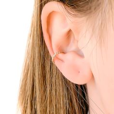 a woman's ear with a gold ring on it