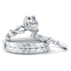 two wedding rings with leaves and diamonds on each one, set against a white background