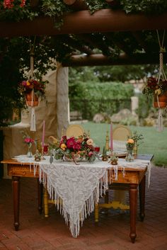 a table with flowers and candles on it in the middle of an outdoor patio area