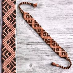 a brown and black beaded tie laying on top of a wooden table next to a piece of string