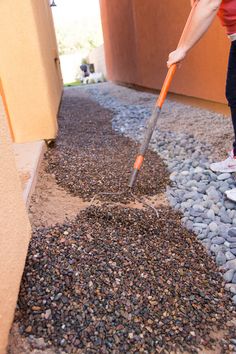 a person is using a shovel to clean the gravel