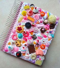 a spiral notebook covered in lots of assorted candies and donuts on it