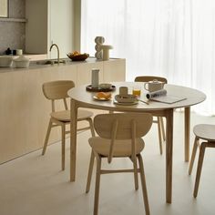 a kitchen table with chairs around it in front of a sink and counter top area