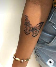 a woman's arm with a butterfly tattoo on the left side of her arm