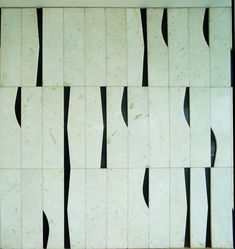 a white and black tiled wall with some lines on the tiles in front of it