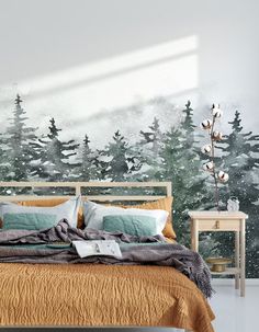 a bed room with a neatly made bed and trees on the wall behind it in front of a window