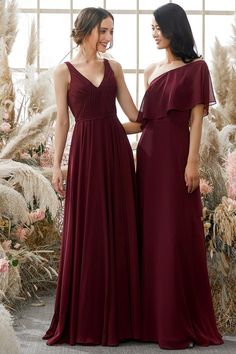 two women in long dresses standing next to each other