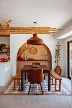 a kitchen with an oven and dining table in the center, surrounded by potted plants