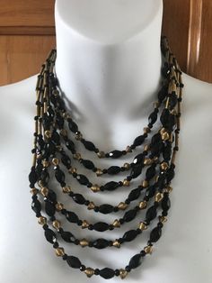 This is a beautiful 1940s art deco black glass and brass bead multi strand necklace The shortest strand measures 15 1/2 inches The longest strand measures 23 inches. The black glass beads measure 7mm x 11mm The gold coLor beads are brass and have Varying shades of patina. Overall this necklace is in very good preowned vintage condition Traditional Multi-strand Black Beaded Necklaces, Vintage Multi-strand Necklace With Large Beads, Vintage Multi-strand Necklaces With Polished Beads, Black Multi-strand Necklace With Faceted Beads, Black Multi-strand Costume Jewelry Necklace, Gold Hands, Glass Bead Necklace, Multi Strand Necklace, Strand Necklace